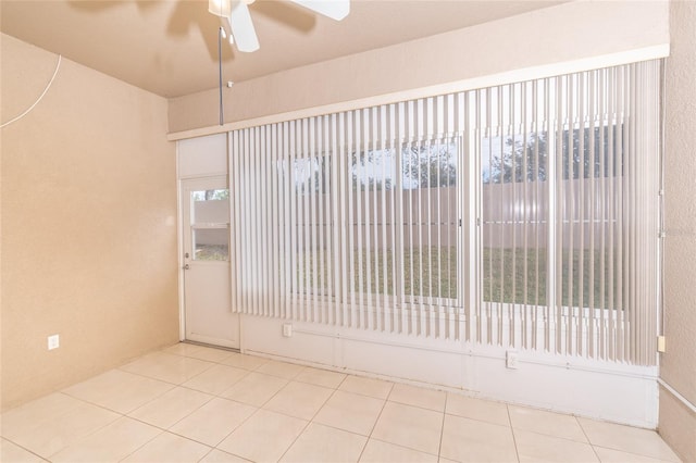 tiled empty room featuring ceiling fan