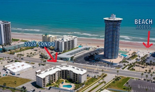 birds eye view of property featuring a view of city, a beach view, and a water view