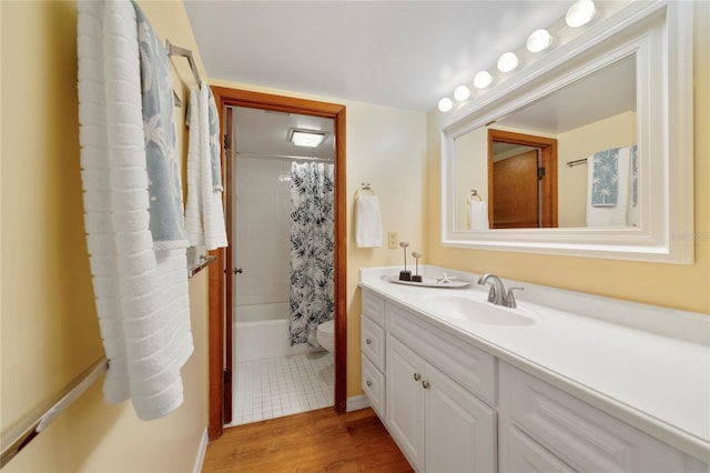 full bath with toilet, shower / tub combo with curtain, wood finished floors, and vanity