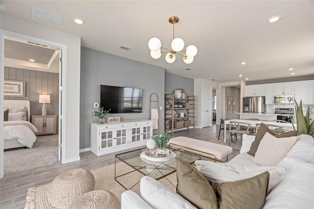 living room featuring a chandelier and light wood-type flooring