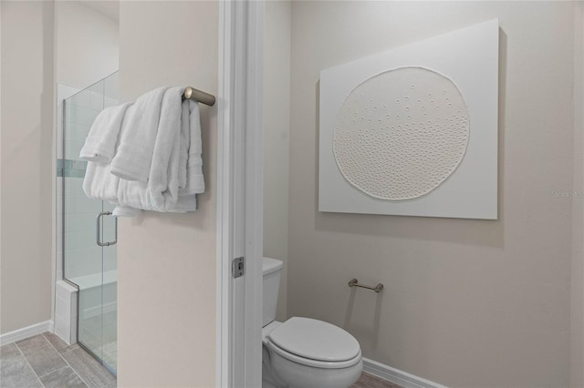 bathroom featuring toilet and an enclosed shower