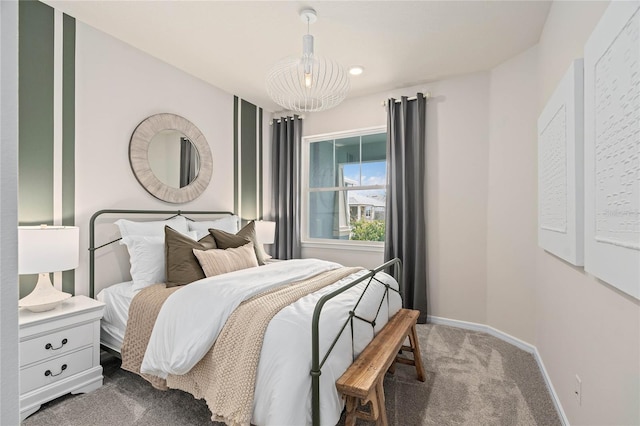 bedroom with dark colored carpet and an inviting chandelier