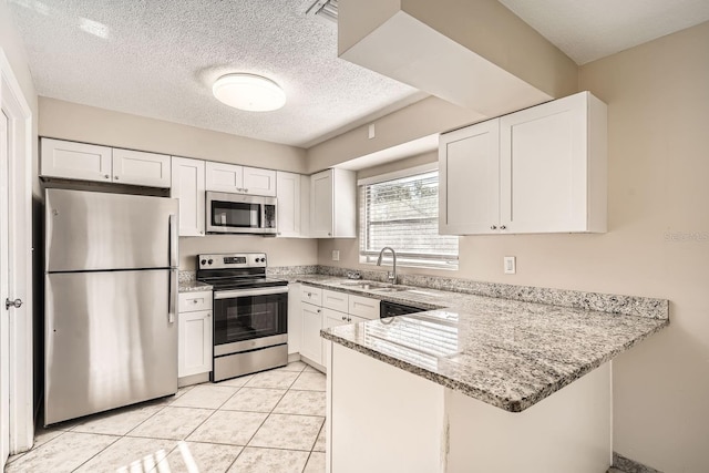 kitchen featuring kitchen peninsula, sink, white cabinets, and appliances with stainless steel finishes