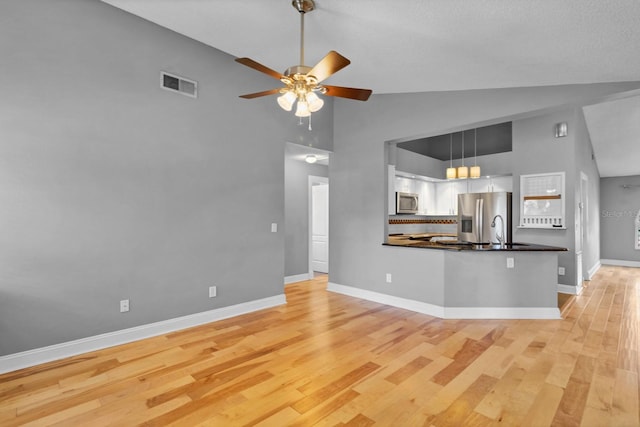 unfurnished living room with ceiling fan, sink, light hardwood / wood-style floors, and high vaulted ceiling