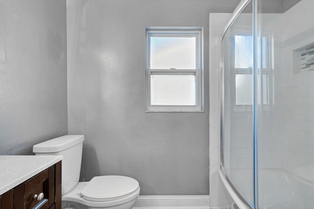 full bathroom with vanity, bath / shower combo with glass door, and toilet