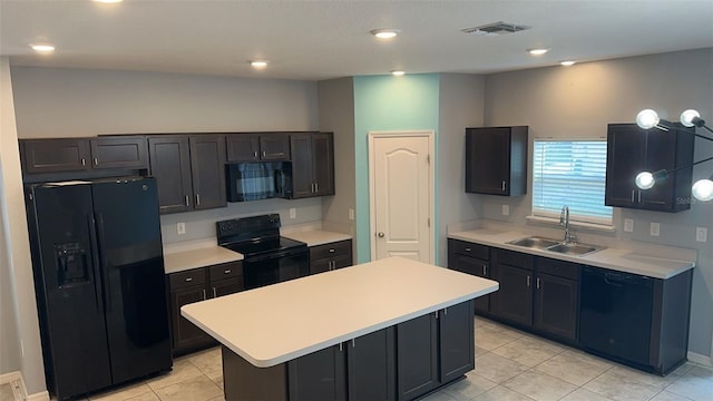 kitchen featuring a center island, light tile patterned flooring, black appliances, and sink