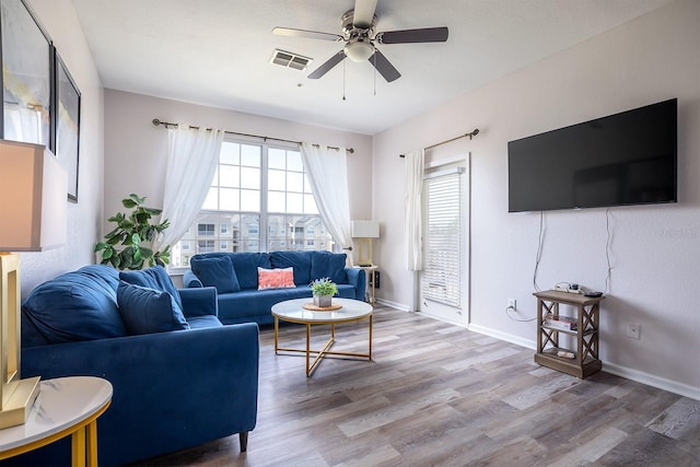 living room with ceiling fan and light hardwood / wood-style floors