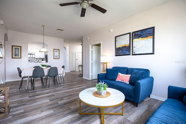 living room featuring ceiling fan and hardwood / wood-style flooring