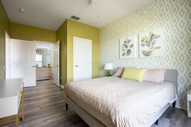 bedroom featuring dark hardwood / wood-style flooring and ensuite bath