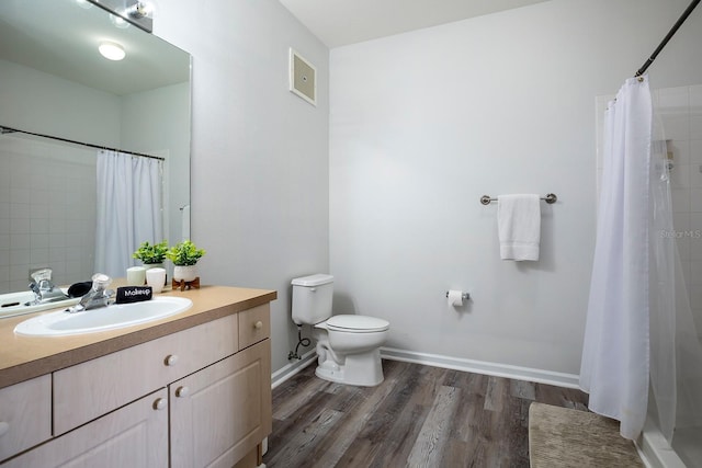 bathroom with curtained shower, hardwood / wood-style floors, vanity, and toilet