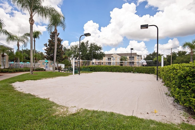 view of property's community with volleyball court and a lawn