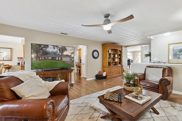 living room with light hardwood / wood-style floors and ceiling fan