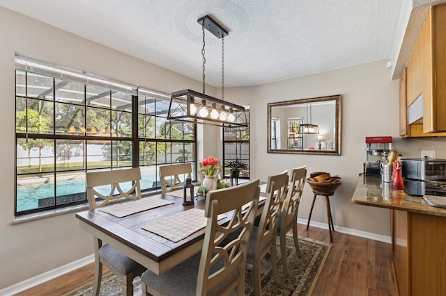 dining area with dark wood-type flooring and a textured ceiling