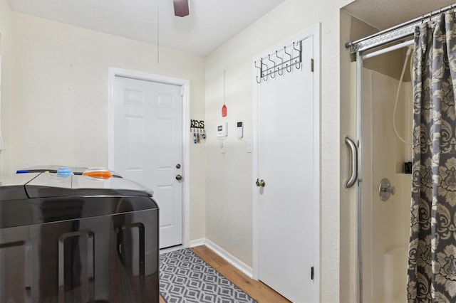 clothes washing area with hardwood / wood-style flooring, ceiling fan, and washing machine and clothes dryer