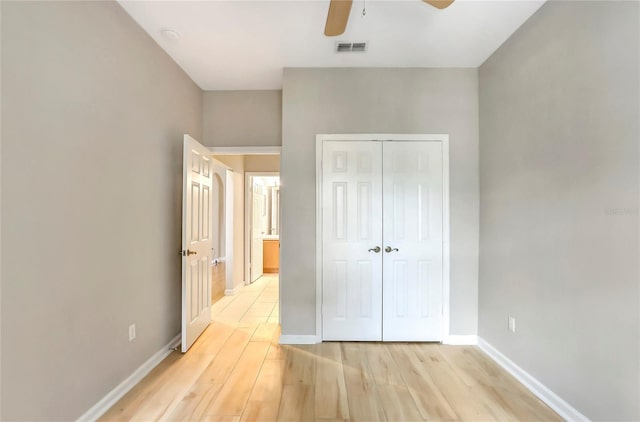 unfurnished bedroom with ceiling fan, light hardwood / wood-style floors, and a closet