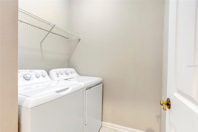 laundry area featuring light tile patterned floors and washer and clothes dryer