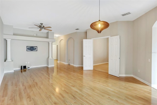 unfurnished living room featuring light hardwood / wood-style floors, decorative columns, and ceiling fan