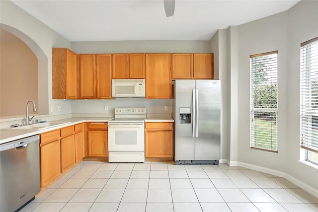 kitchen featuring a healthy amount of sunlight, appliances with stainless steel finishes, sink, and light tile patterned floors