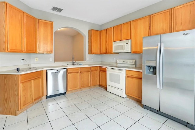 kitchen featuring stainless steel appliances, sink, and light tile patterned floors