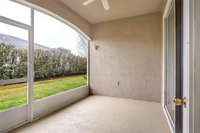 unfurnished sunroom with ceiling fan