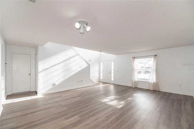 unfurnished living room featuring a textured ceiling and hardwood / wood-style flooring