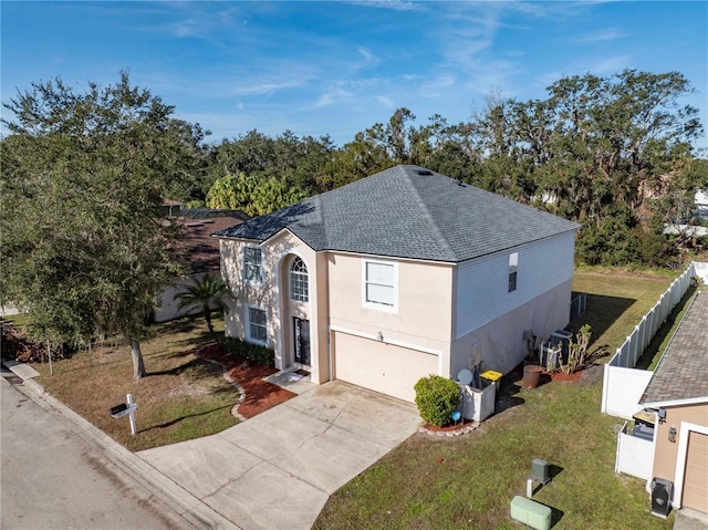 view of front facade with a front yard, central AC, and a garage