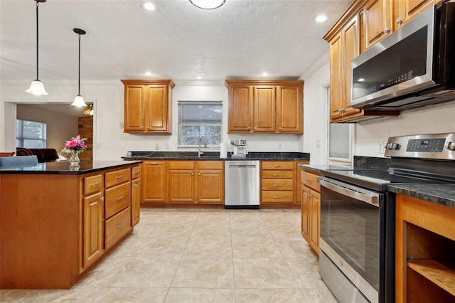 kitchen with hanging light fixtures, sink, ornamental molding, and appliances with stainless steel finishes