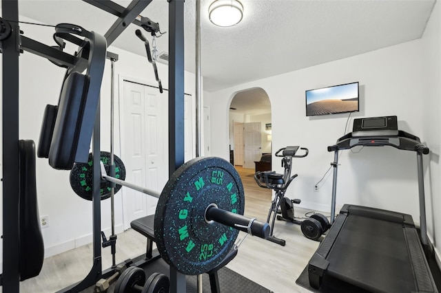 workout room with wood-type flooring and a textured ceiling