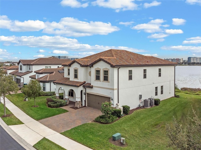 mediterranean / spanish-style home featuring central AC, a garage, a water view, and a front lawn