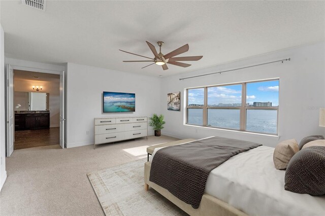 carpeted bedroom with connected bathroom and ceiling fan