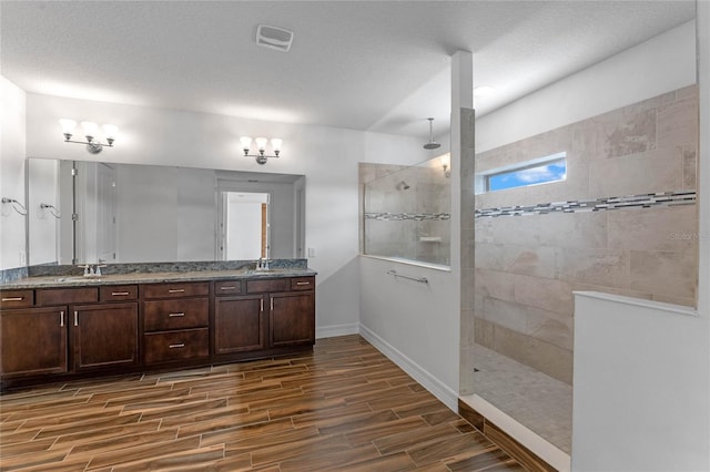 bathroom featuring a tile shower and vanity