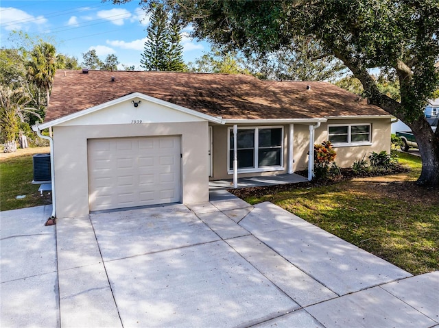 single story home featuring a front lawn, cooling unit, and a garage