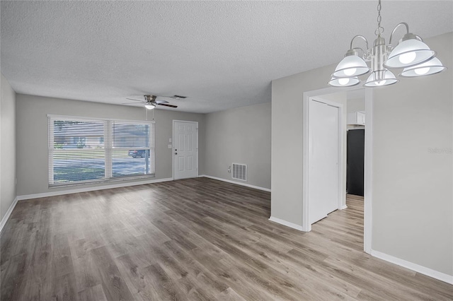 interior space with a textured ceiling, ceiling fan with notable chandelier, and hardwood / wood-style floors