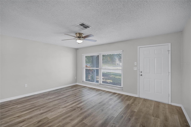 foyer featuring ceiling fan, wood-type flooring, and a textured ceiling