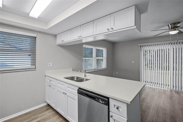 kitchen featuring dishwasher, kitchen peninsula, white cabinets, and sink