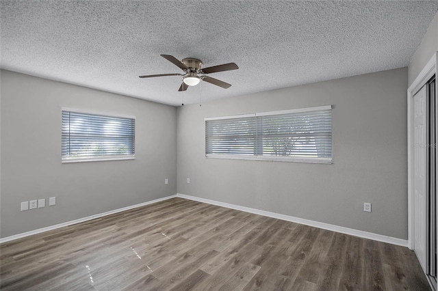 unfurnished bedroom with a closet, a textured ceiling, hardwood / wood-style flooring, and ceiling fan