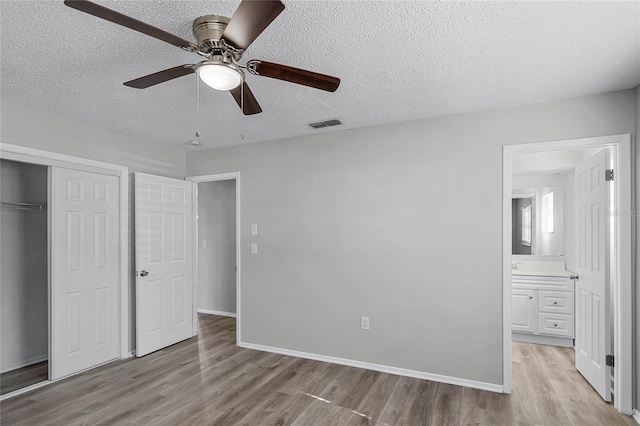 unfurnished bedroom with ensuite bath, ceiling fan, a closet, and a textured ceiling