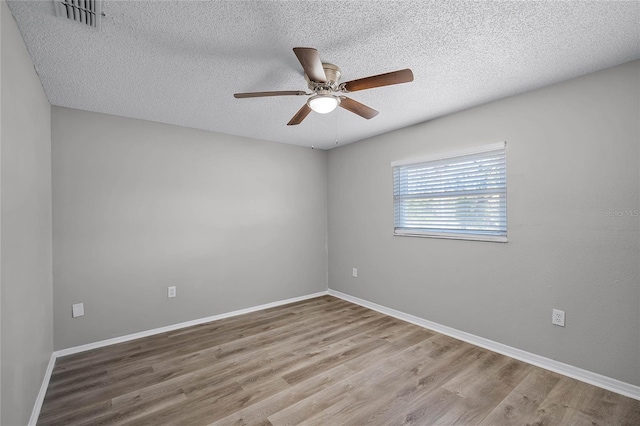 spare room featuring ceiling fan, hardwood / wood-style floors, and a textured ceiling