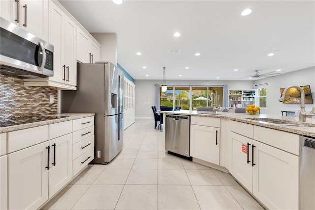 kitchen featuring light stone countertops, sink, stainless steel appliances, and tasteful backsplash