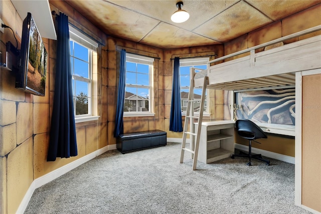 carpeted bedroom with wooden walls