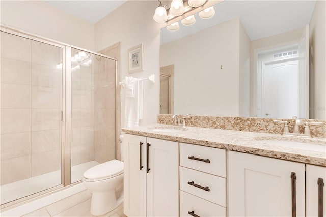 bathroom featuring a shower with shower door, vanity, tile patterned floors, and toilet