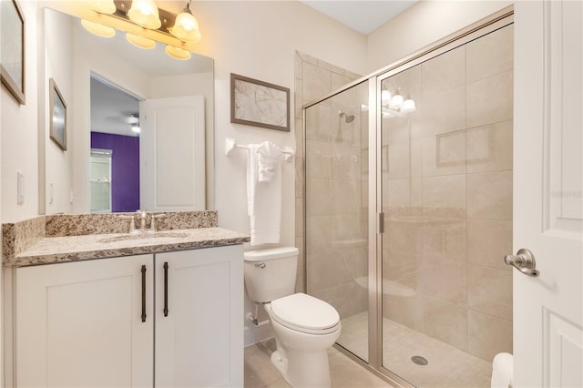 bathroom featuring toilet, vanity, and a shower with door