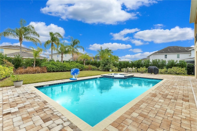 view of pool with grilling area, an in ground hot tub, a yard, and a patio