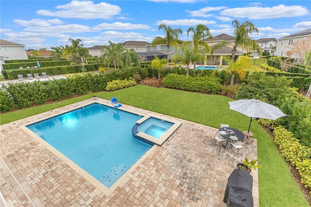 view of swimming pool with an in ground hot tub, a lawn, and a patio