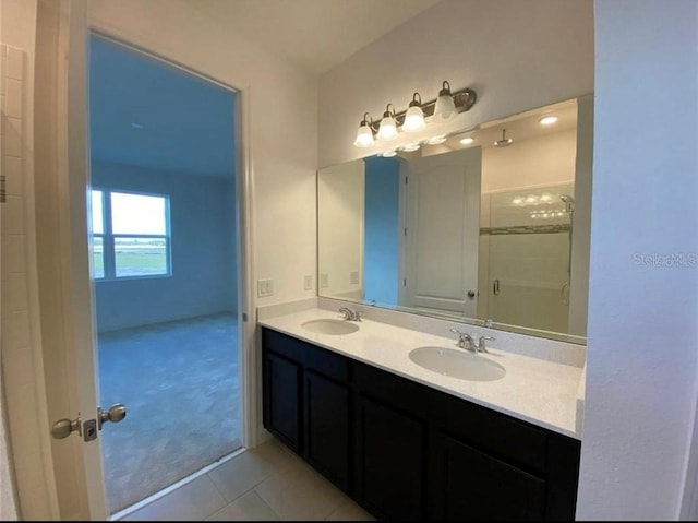 bathroom featuring tile patterned flooring, vanity, and a shower with door