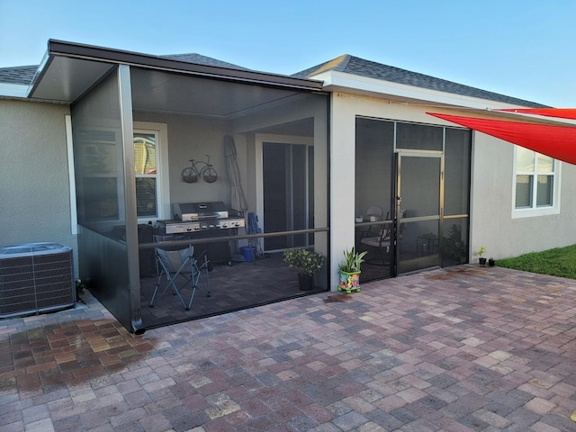 view of patio / terrace featuring a grill, a sunroom, and central AC unit