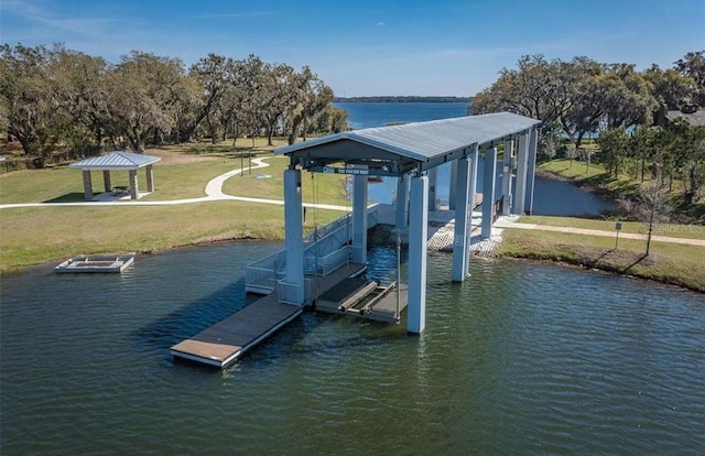 dock area with a gazebo, a water view, and a lawn