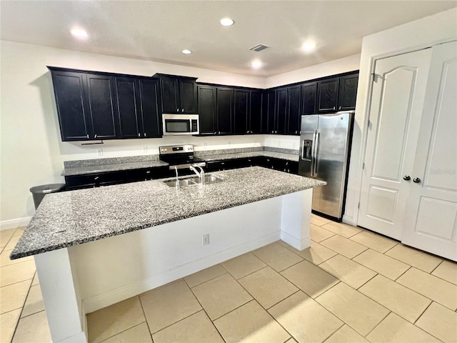 3333 Wauseon Dr, Saint Cloud, FL 34772 - kitchen with stainless steel appliances, dark cabinets, light tile patterned floors, and recessed lighting