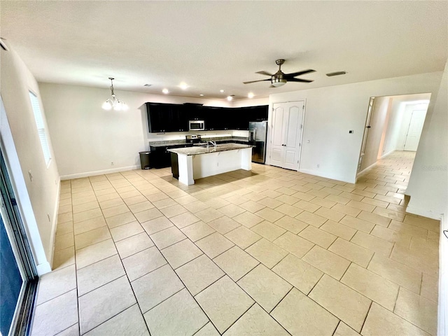 3333 Wauseon Dr, Saint Cloud, FL 34772 - kitchen with stainless steel appliances, dark cabinetry, open floor plan, a ceiling fan, and recessed lighting