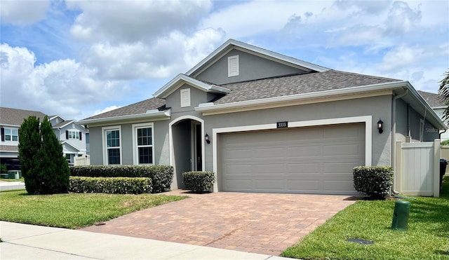 3333 Wauseon Dr, Saint Cloud, FL 34772 - ranch-style home featuring stucco siding, decorative driveway, a front lawn, roof with shingles, and an attached garage